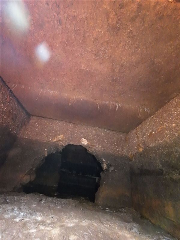 Large hole in the wall of a homemade septic tank