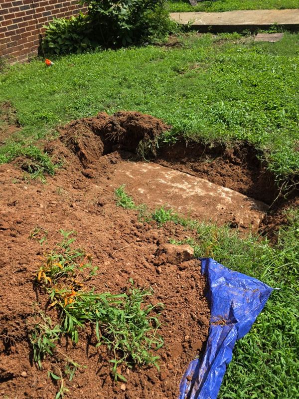 Septic tank lid uncovered in the soil