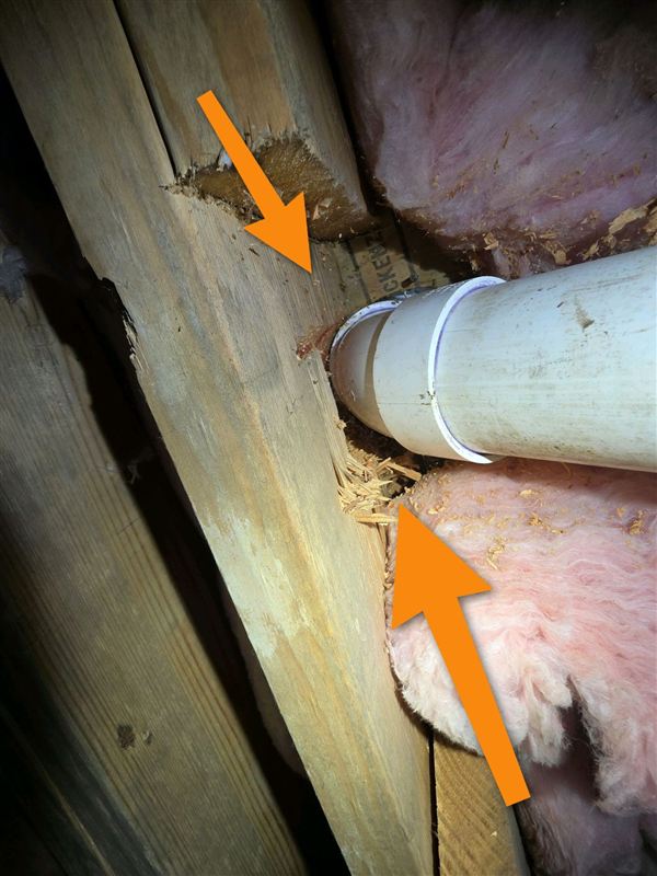 Wood joist notched at a plumbing pipe