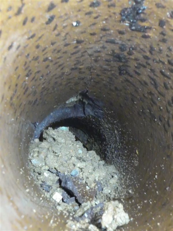 Cracked septic pipe with soil packed inside